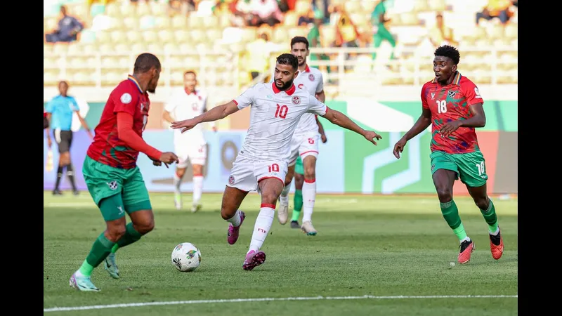 Cầu thủ Tunisia chạy nhanh với bóng trước sự áp đảo của hậu vệ Namibia