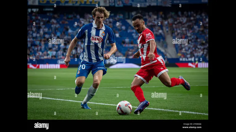 Cầu thủ của Espanyol với chiếc áo xanh đang tấn công trước hàng phòng ngự của Rayo…